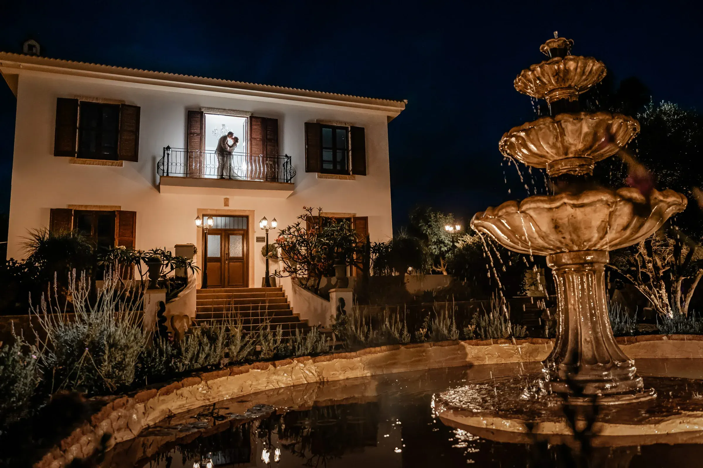 Couple kissing beside the illuminated fountain at night